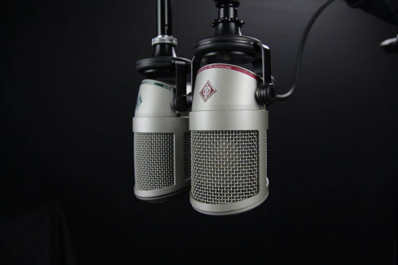 heros-img Close-up of two professional microphones in a recording studio, ideal for podcasts and music production.